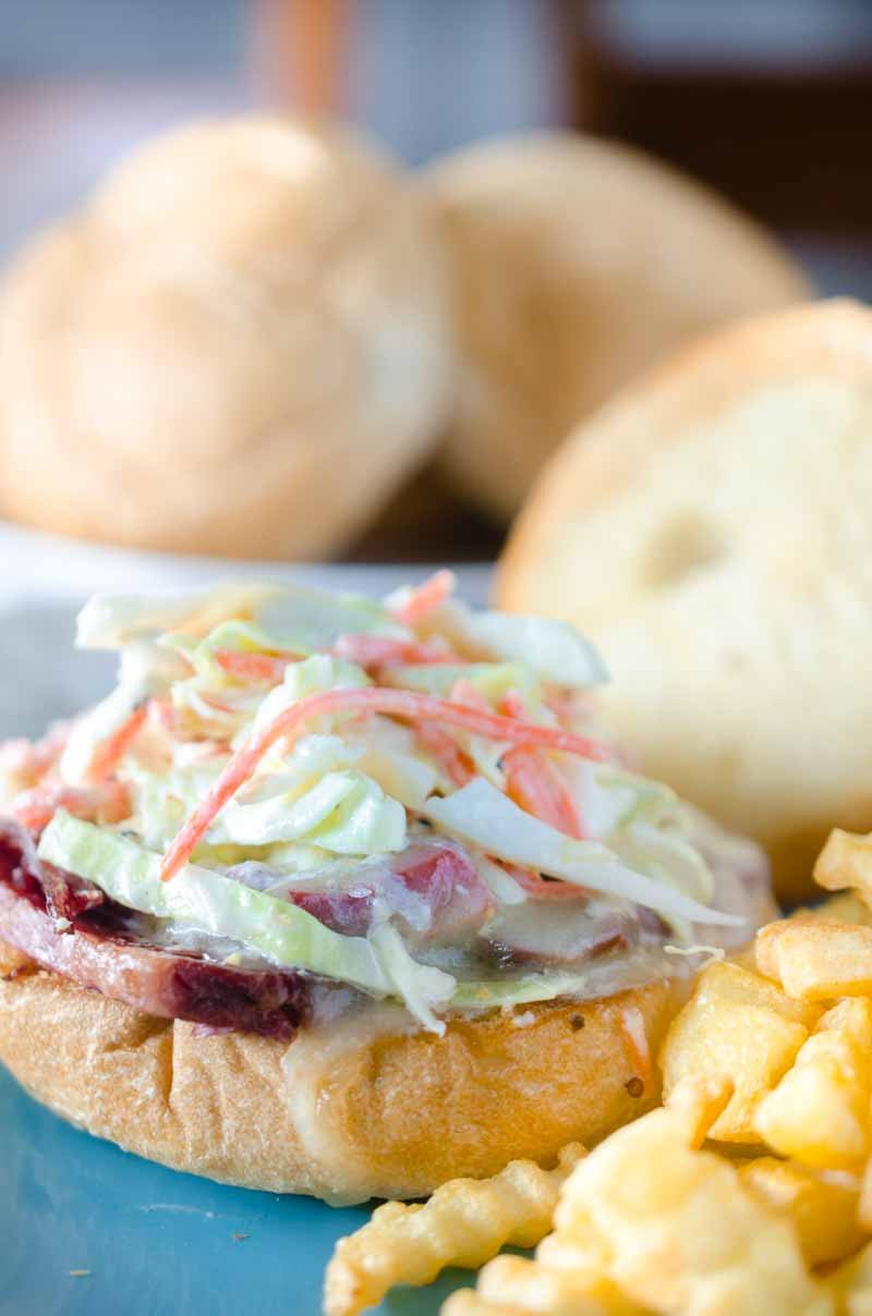 Ultimate Corned Beef Sandwiches topped with melted Swiss cheese and a creamy horseradish slaw. 