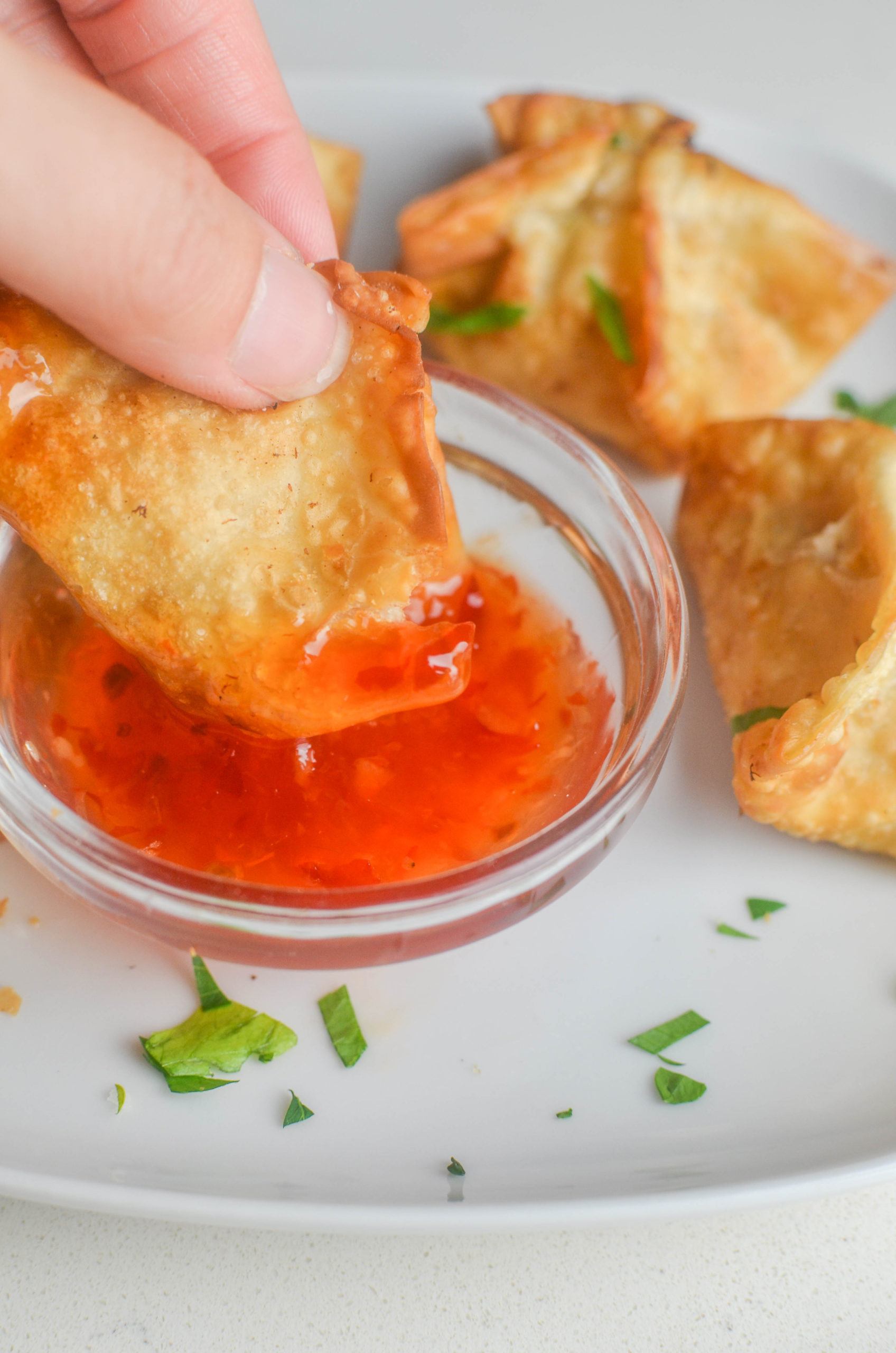 Dipping wonton in sweet thai chili sauce. 