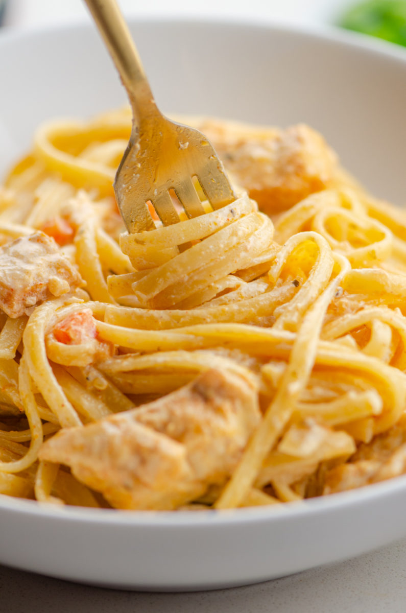 A fork twirling creamy cajun chicken pasta. 