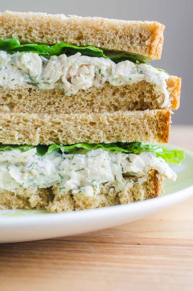 A creamy dill chicken salad sandwich made with fresh dill, mayo, yogurt, garlic, chicken and red onion. The perfect summer sandwich.