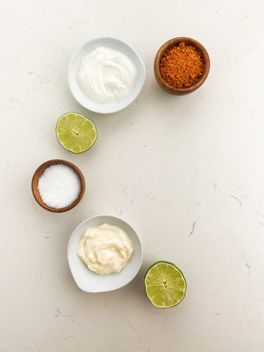 Overhead photo of creamy taco sauce ingredients in bowls on a white background. 