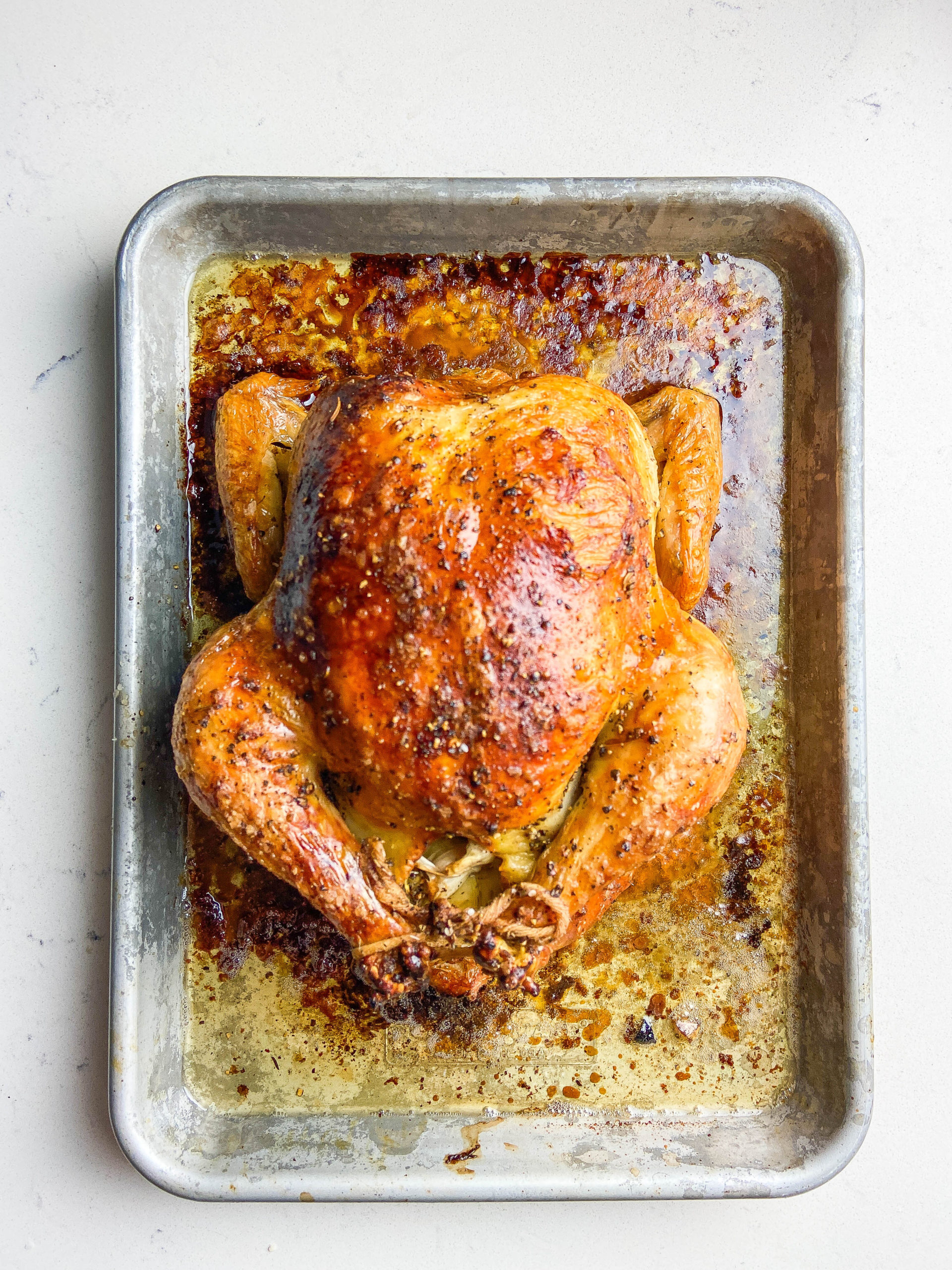 Overhead photo of crispy oven roasted chicken in a pan.