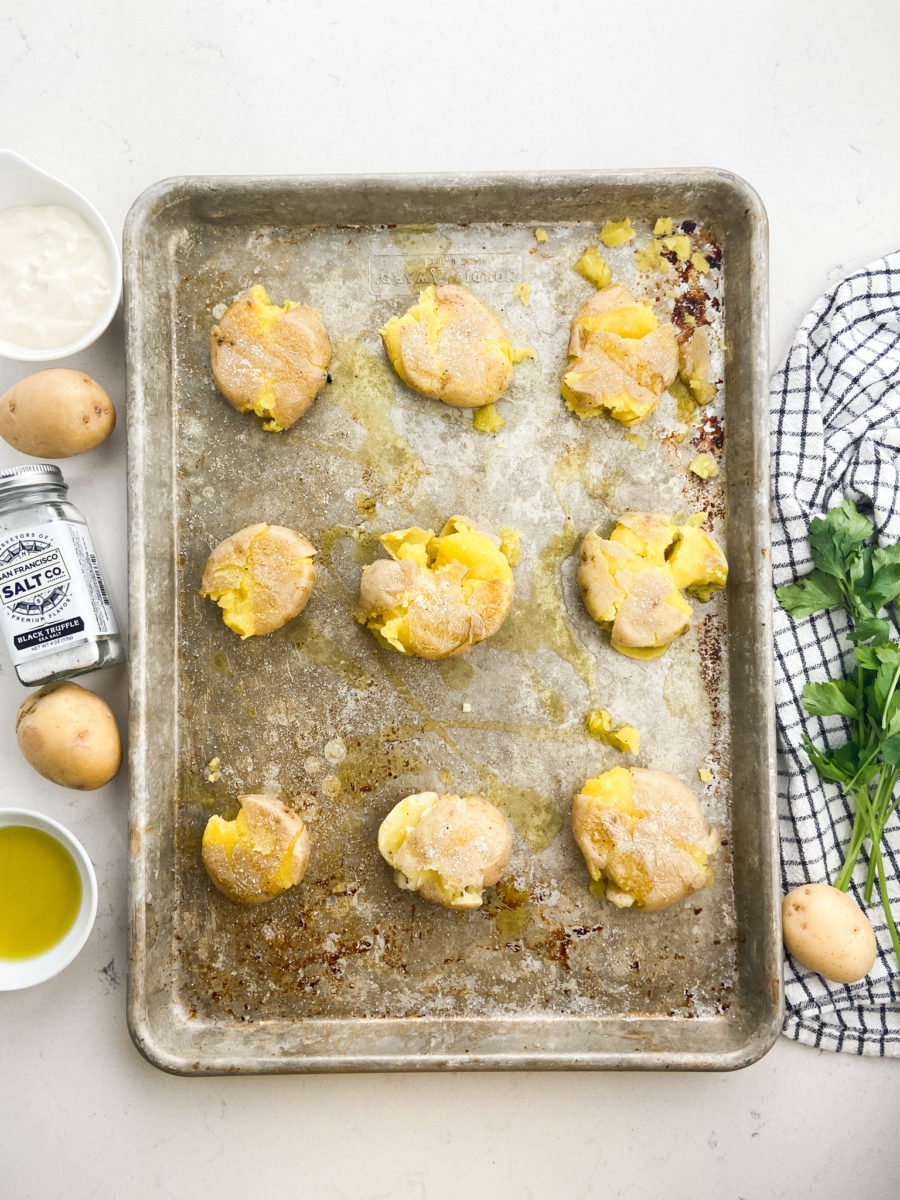 Smashed potatoes on baking sheet.