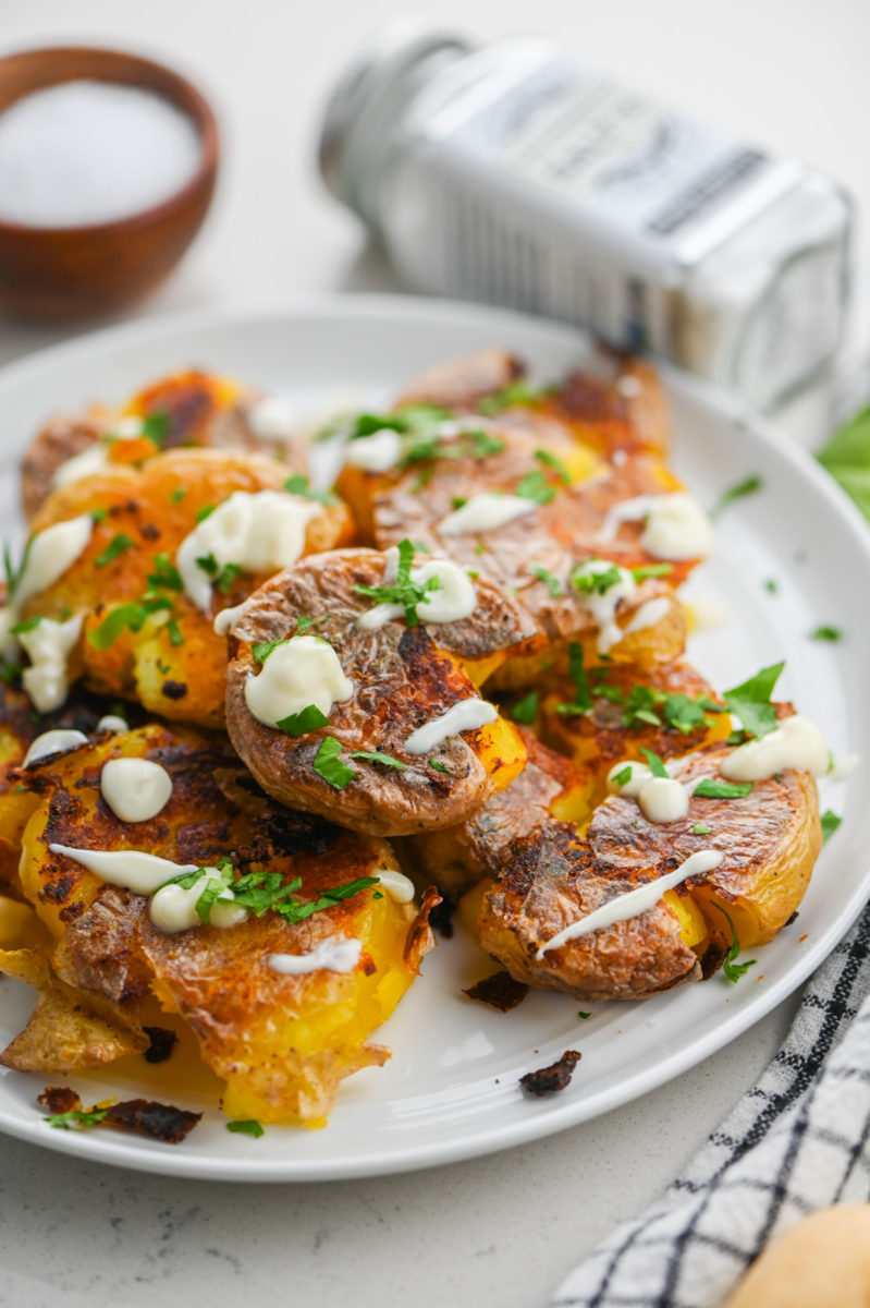 Truffle smashed potatoes on white plate. 