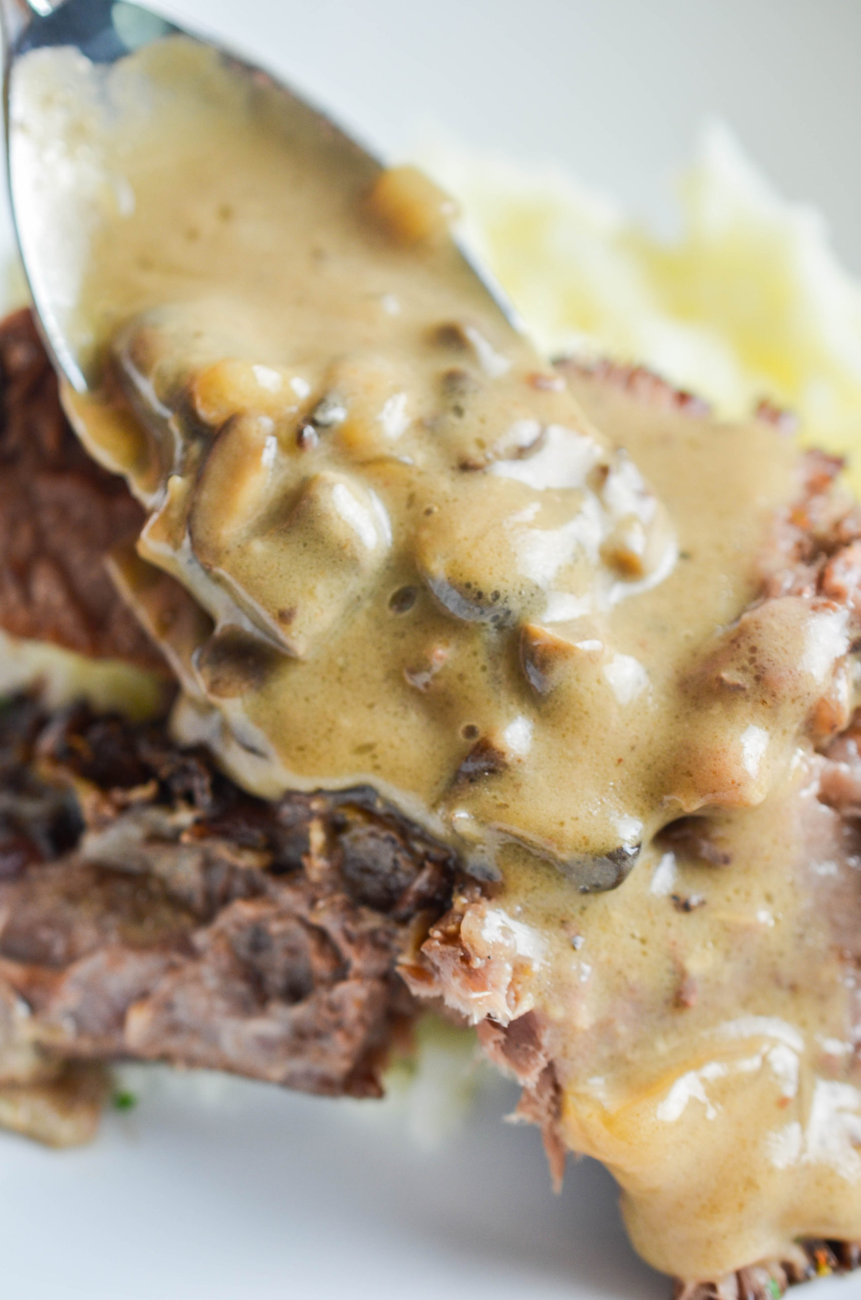 Spooning mushroom gravy over pot roast. 