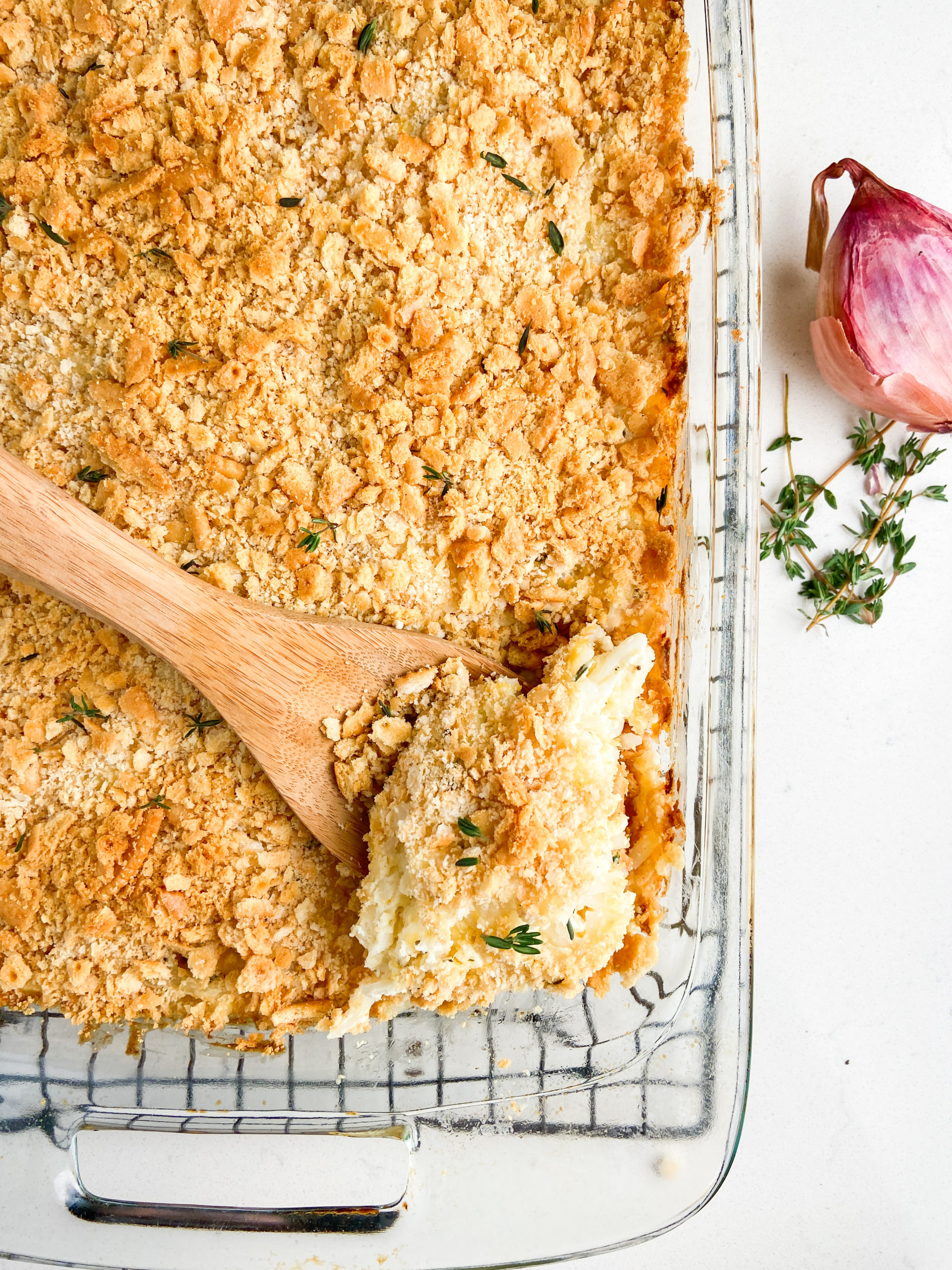 Overhead photo of hashbrown casserole with a wooden spoon in it. 