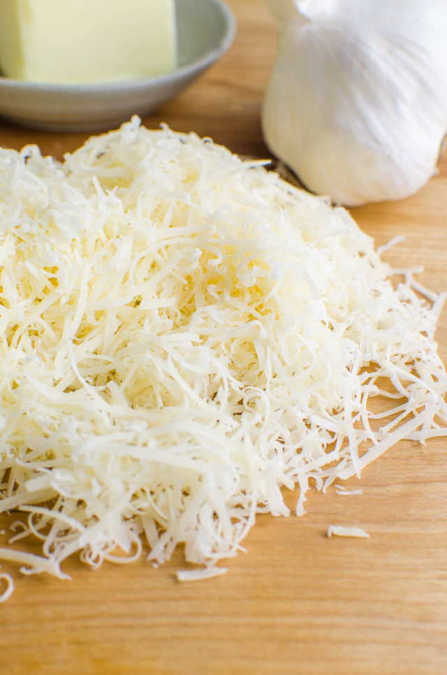 shredded parmesan cheese on a cutting board 
