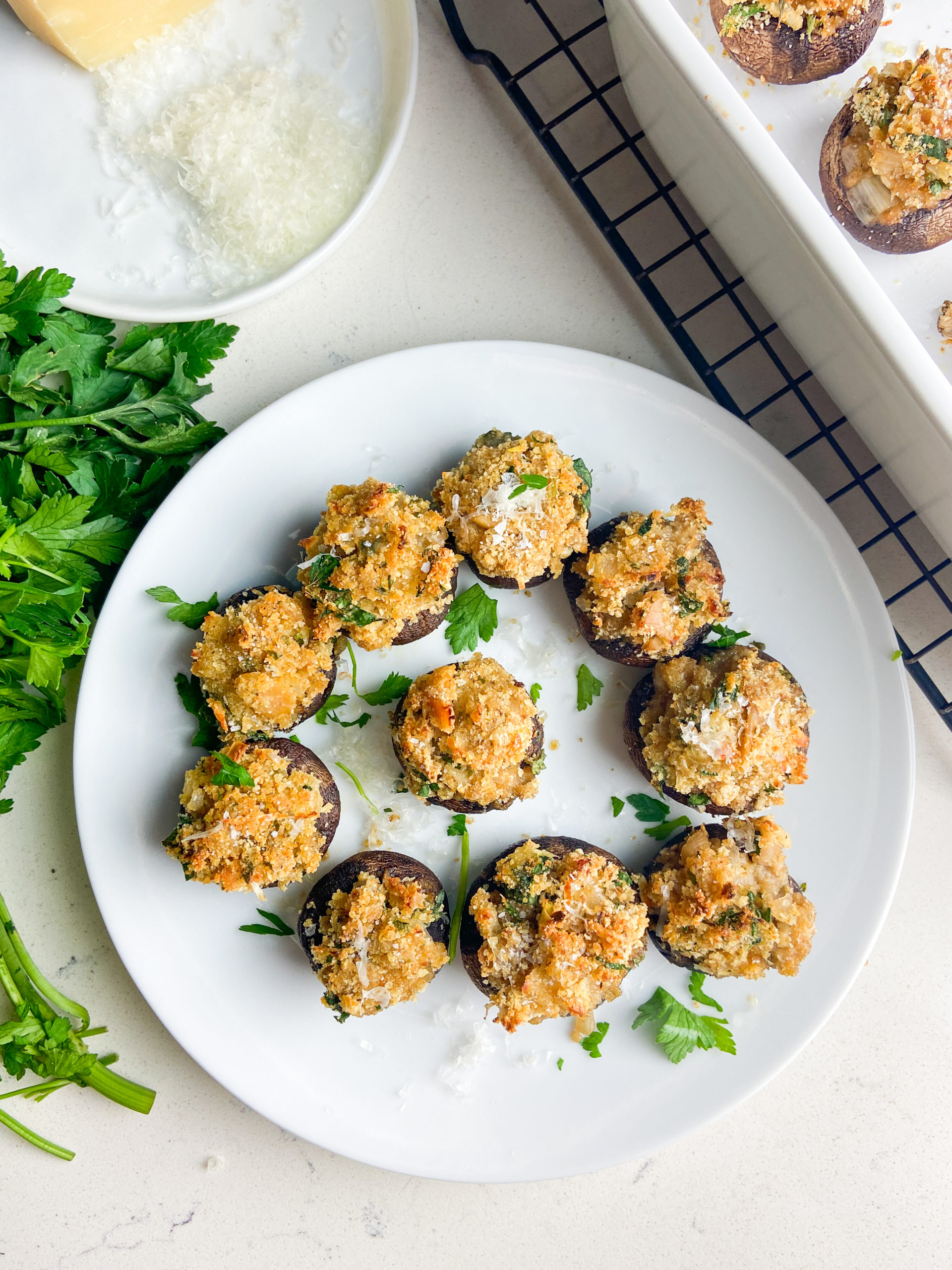 Overhead photo of stuffed mushrooms on white plate. 