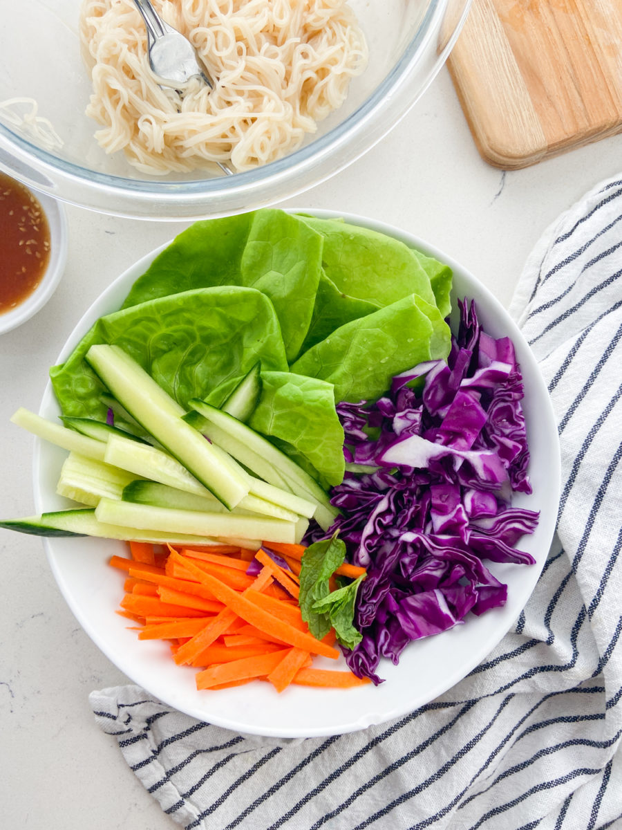 Overhead photo of fresh spring roll ingredients in a white bowl. 