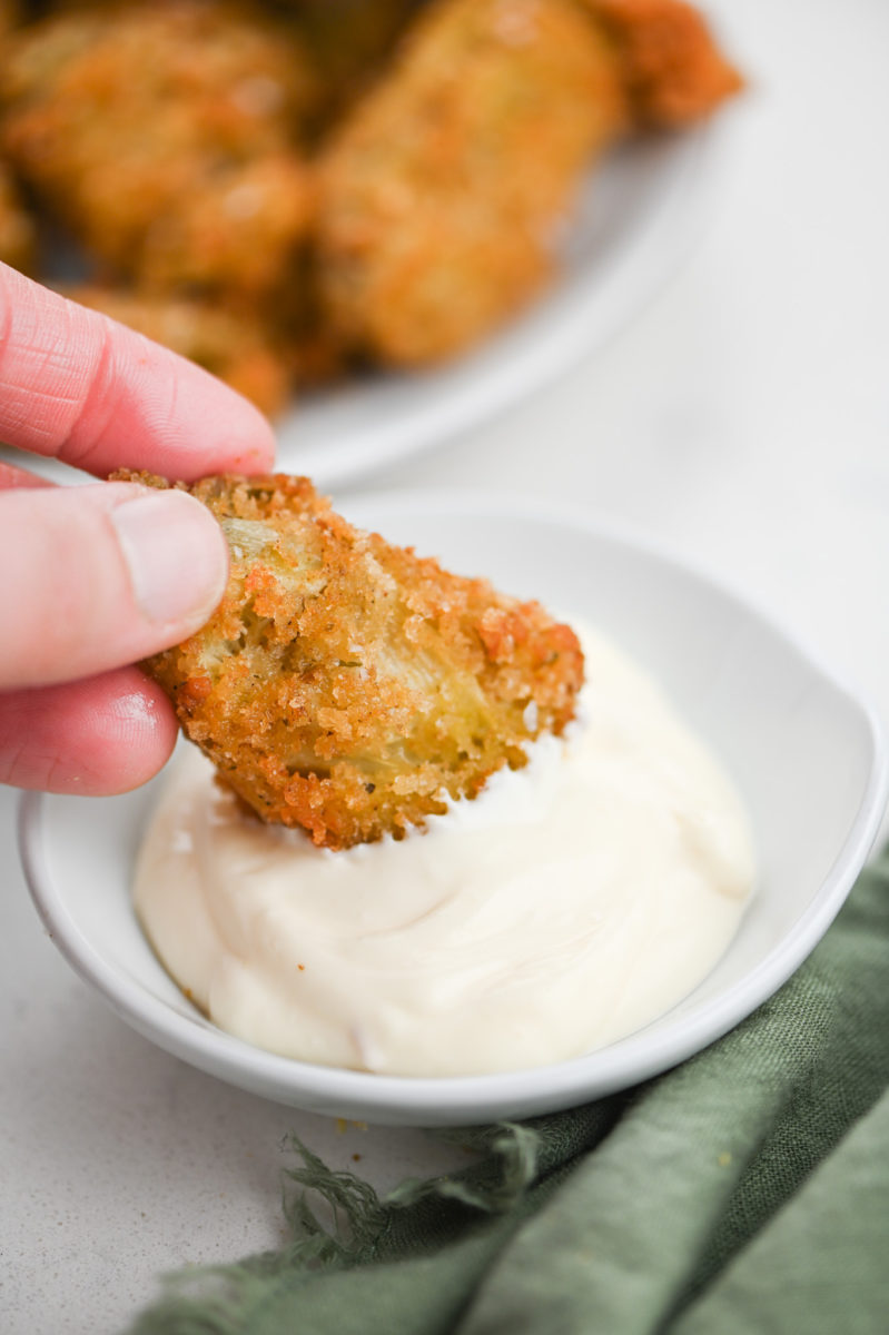 Dipping fried artichoke heart in aioli. 