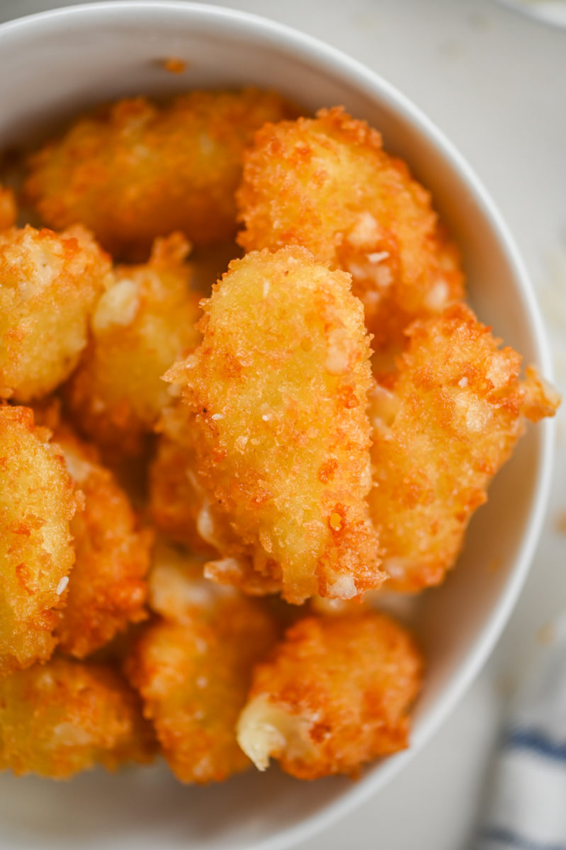 Overhead photo of panko fried cheese curds in a white bowl.