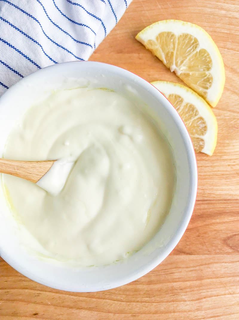 Overhead photo of aioli in a bowl on a cutting board.