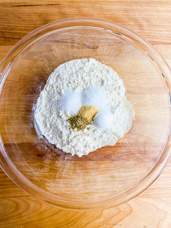 Dry ingredients in a clear bowl on a cutting board. 