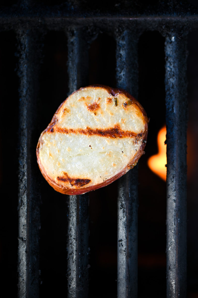 Sliced red potato on grill. 