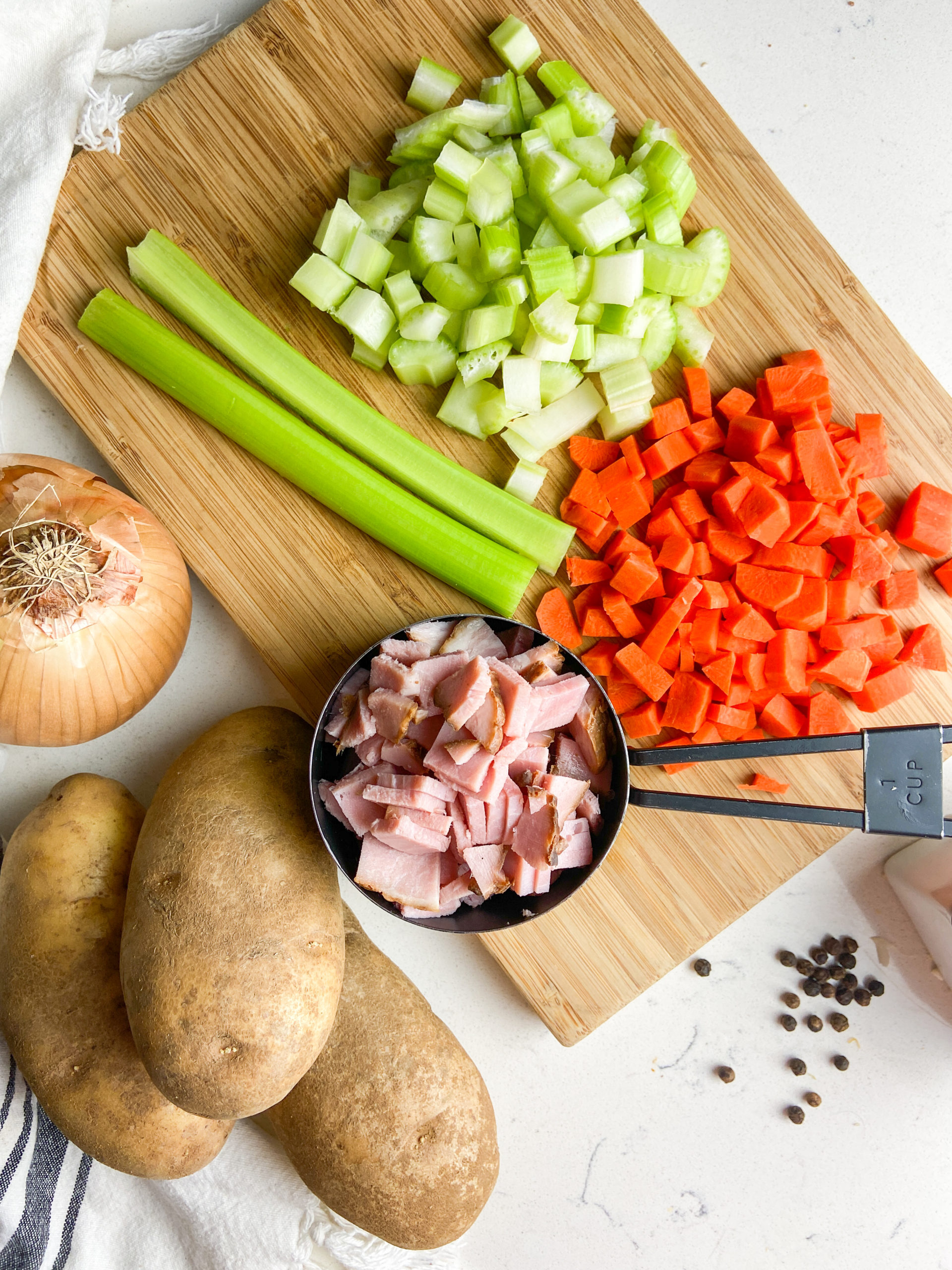 Overhead  photo of ingredients needed for soup on a wooden cutting board. 