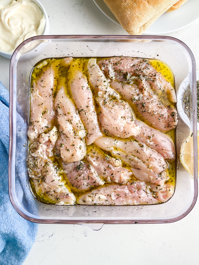 Chicken marinating in plastic container. 