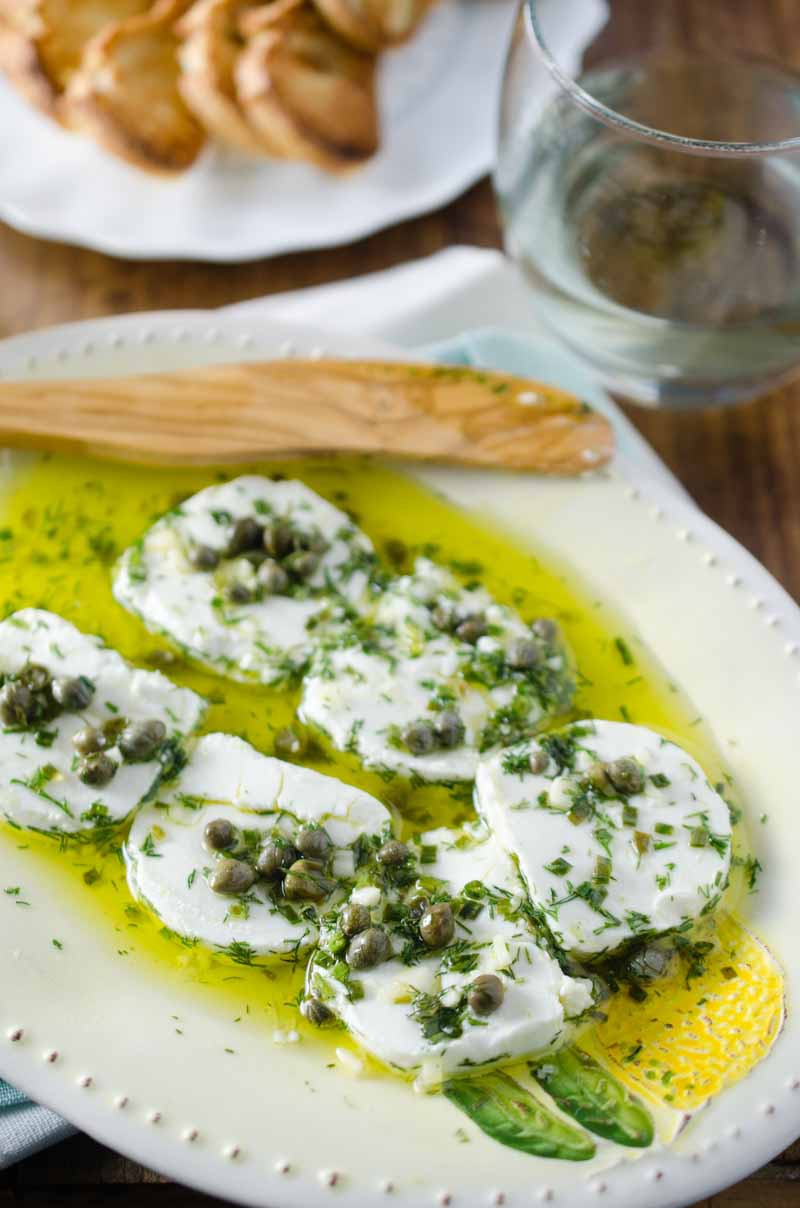 Tangy herb marinated goat cheese is the perfect appetizer to enjoy with a glass of wine. 
