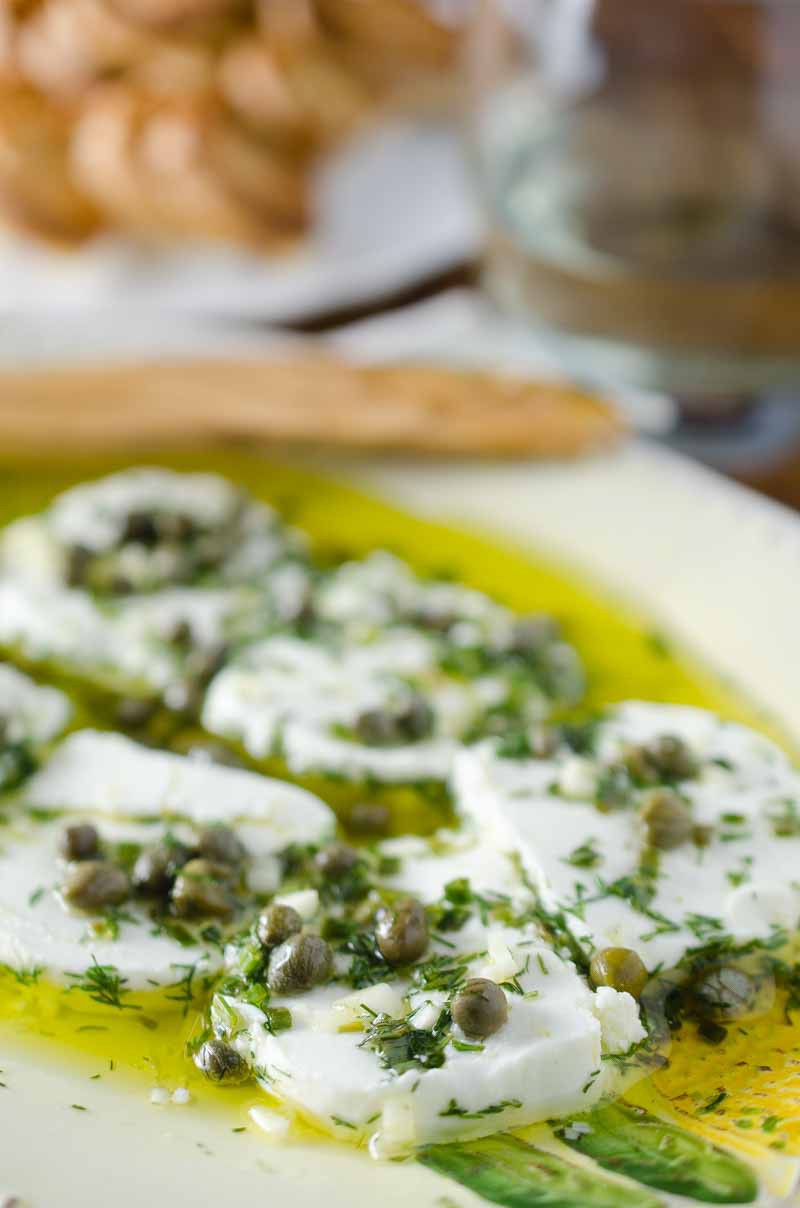 Tangy herb marinated goat cheese is the perfect appetizer to enjoy with a glass of wine. 