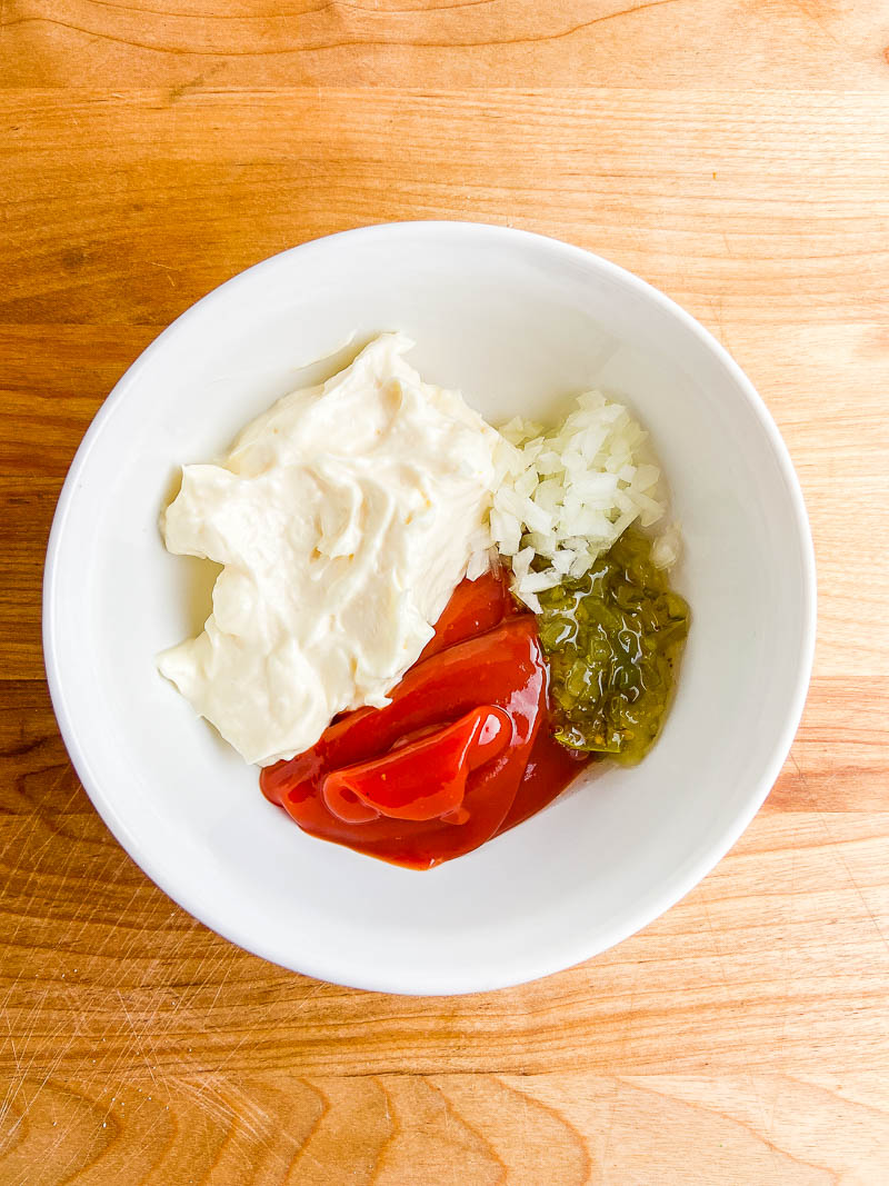 Ingredients for Thousand Island Dressing in a white bowl. 