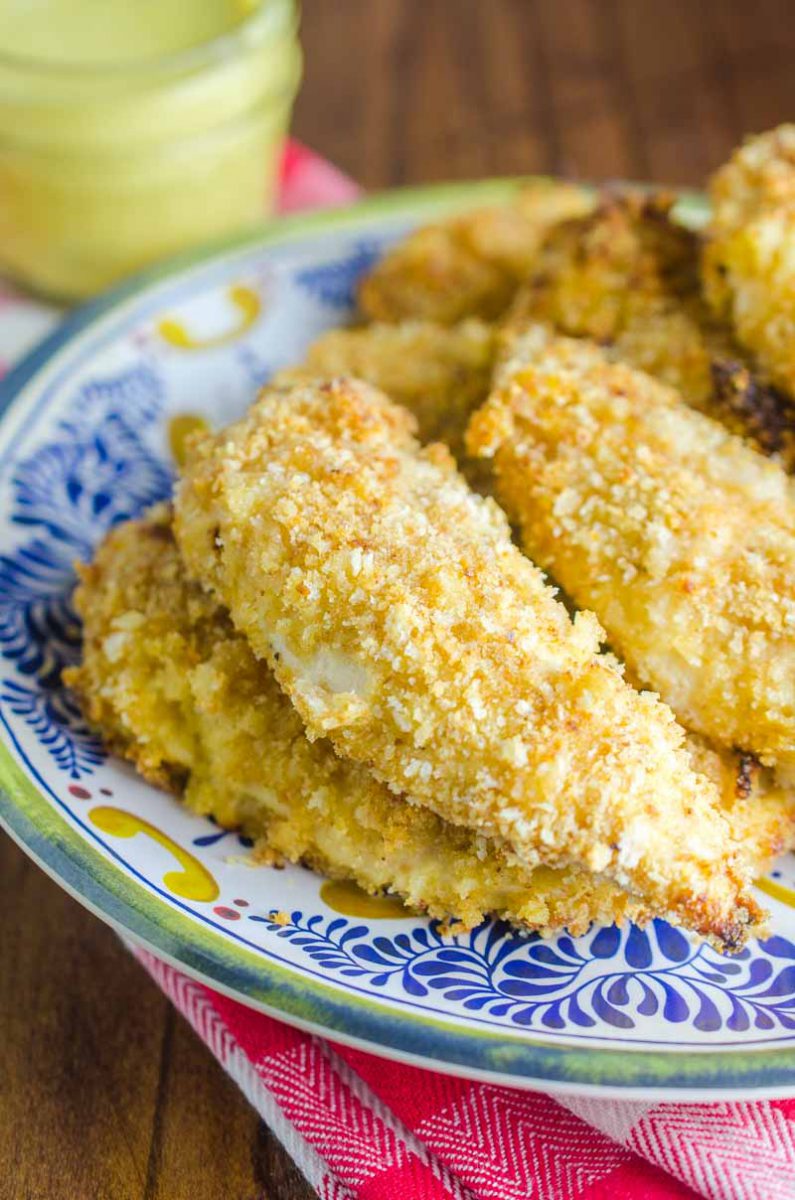 Baked Honey Mustard Chicken Tenders are marinated in honey mustard dressing, dredged in panko and baked until golden. They are a family favorite and perfect for weeknights!