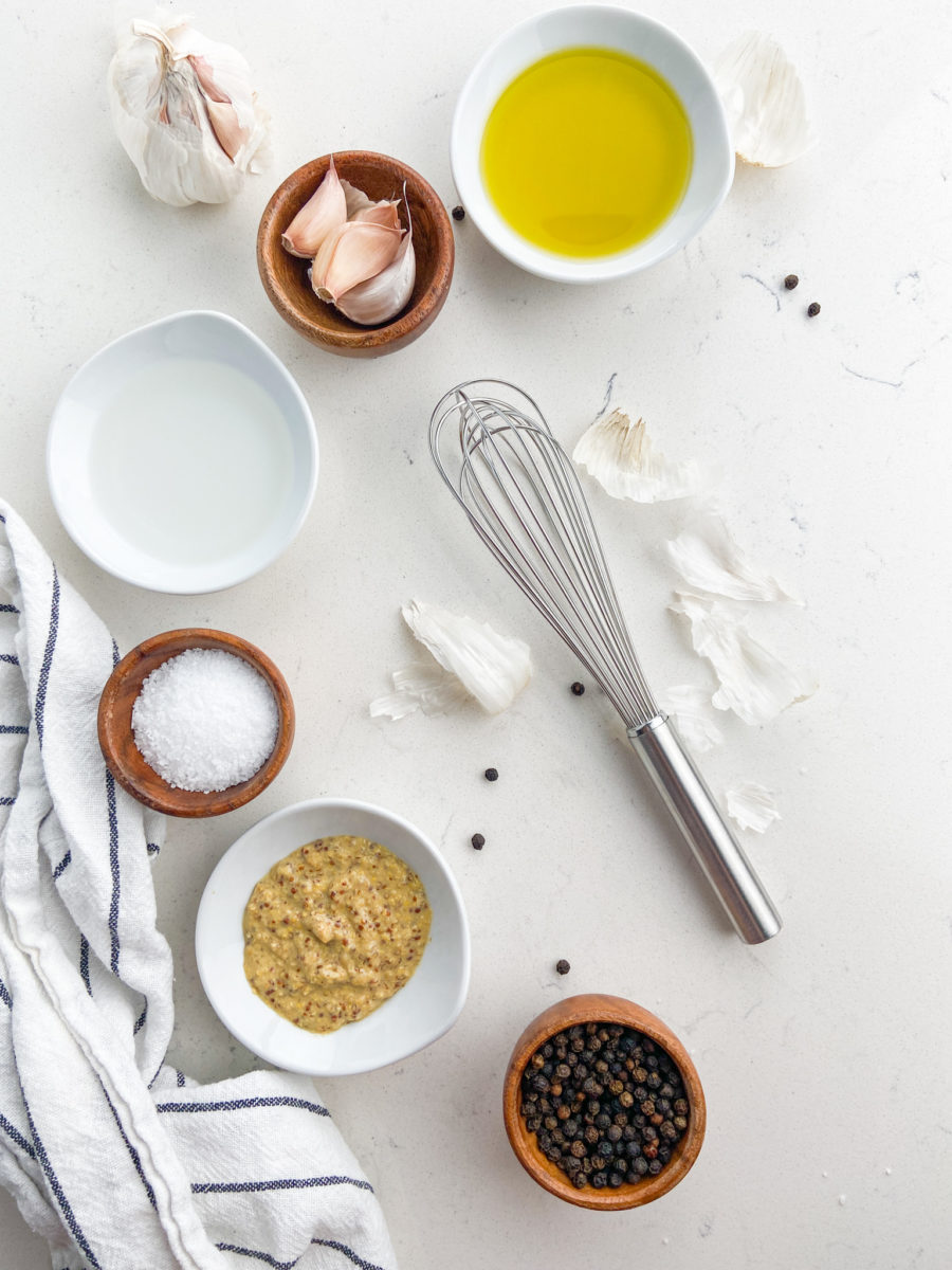 Ingredients needed for garlic vinaigrette on white background. 