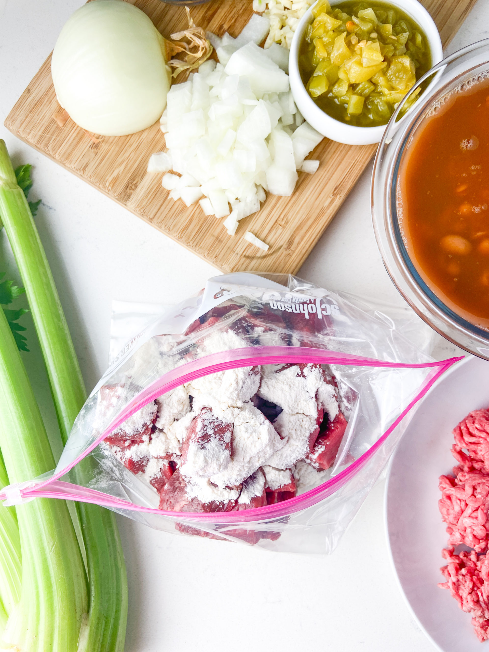 Ingredients for chili overhead with flour coated steak in a bag. 