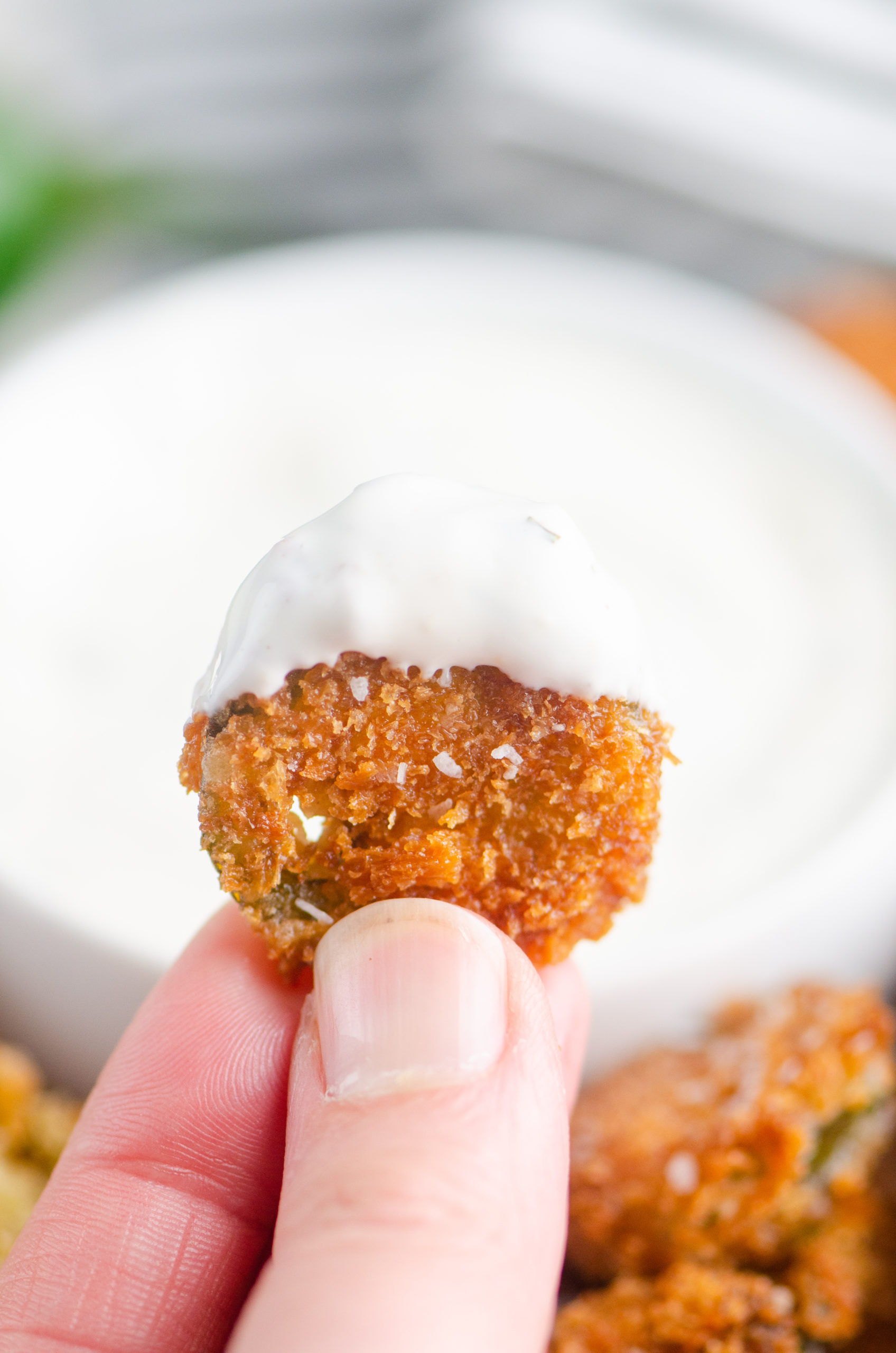 Close up photo of jalapeno bite dipped in ranch. 