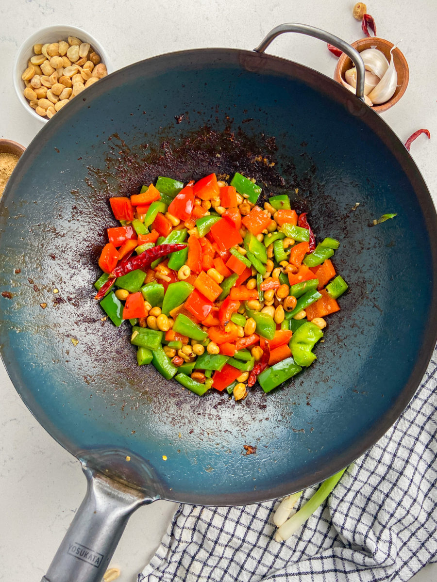 Bell peppers, peanuts and chiles in a wok.