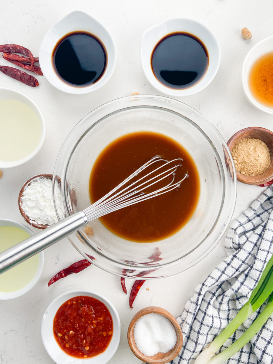 Kung pao sauce in glass bowl with wisk. 