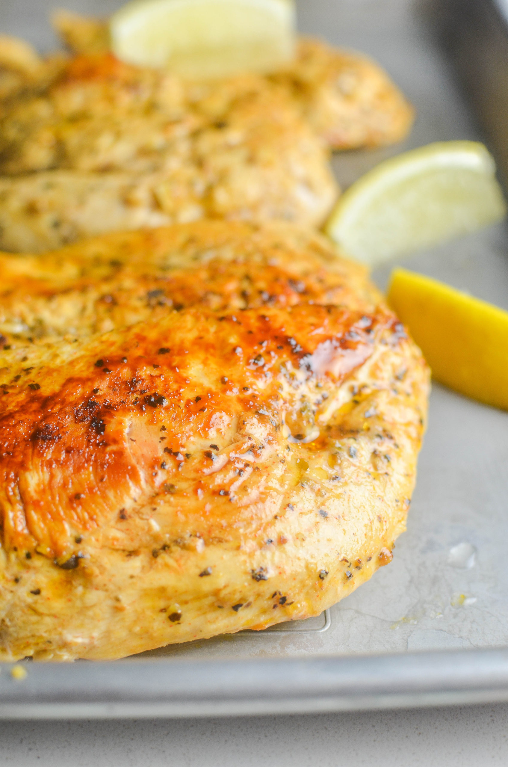 Lemon pepper chicken on a silver baking sheet