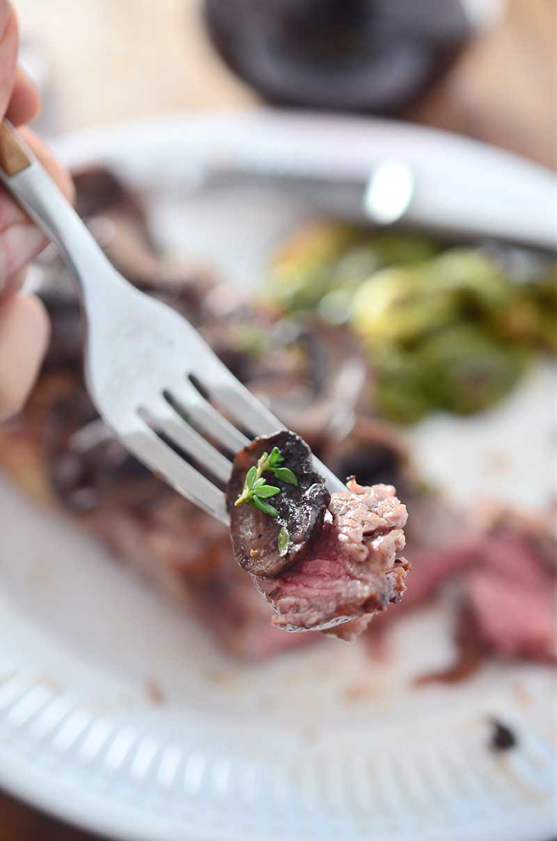 Perfectly grilled New York Strip steak smothered with red wine mushrooms. 