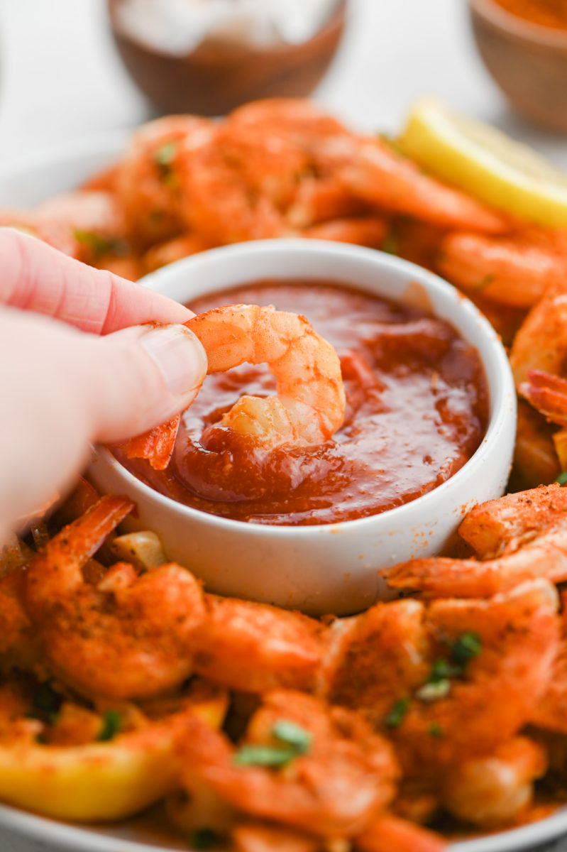 Dipping a shrimp in cocktail sauce. 
