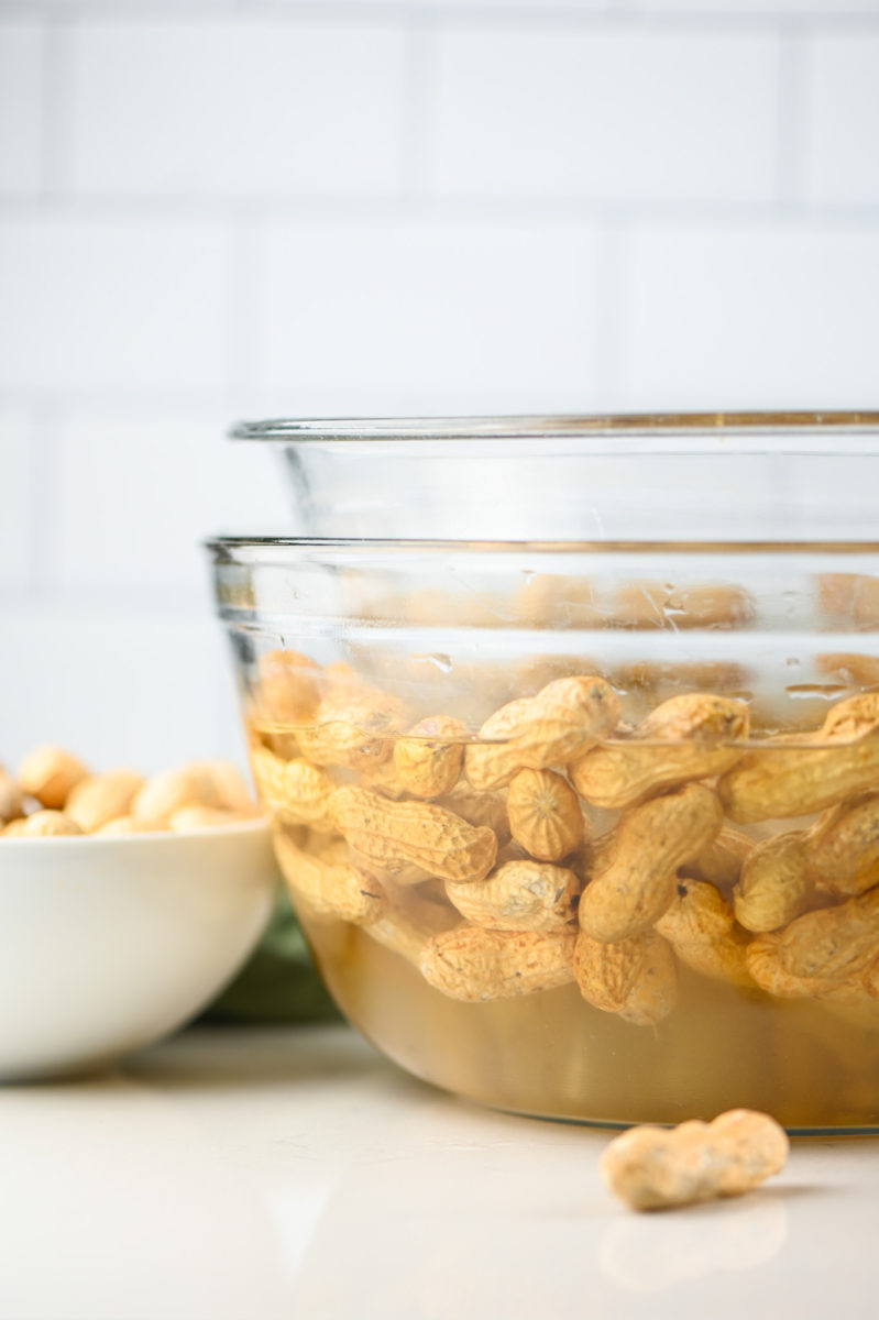 Peanuts soaking in salt water solution in glass bowl. 