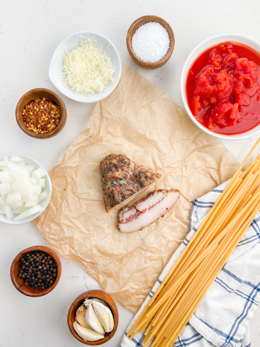 Overhead photo of amatriciana ingredients on white background. 