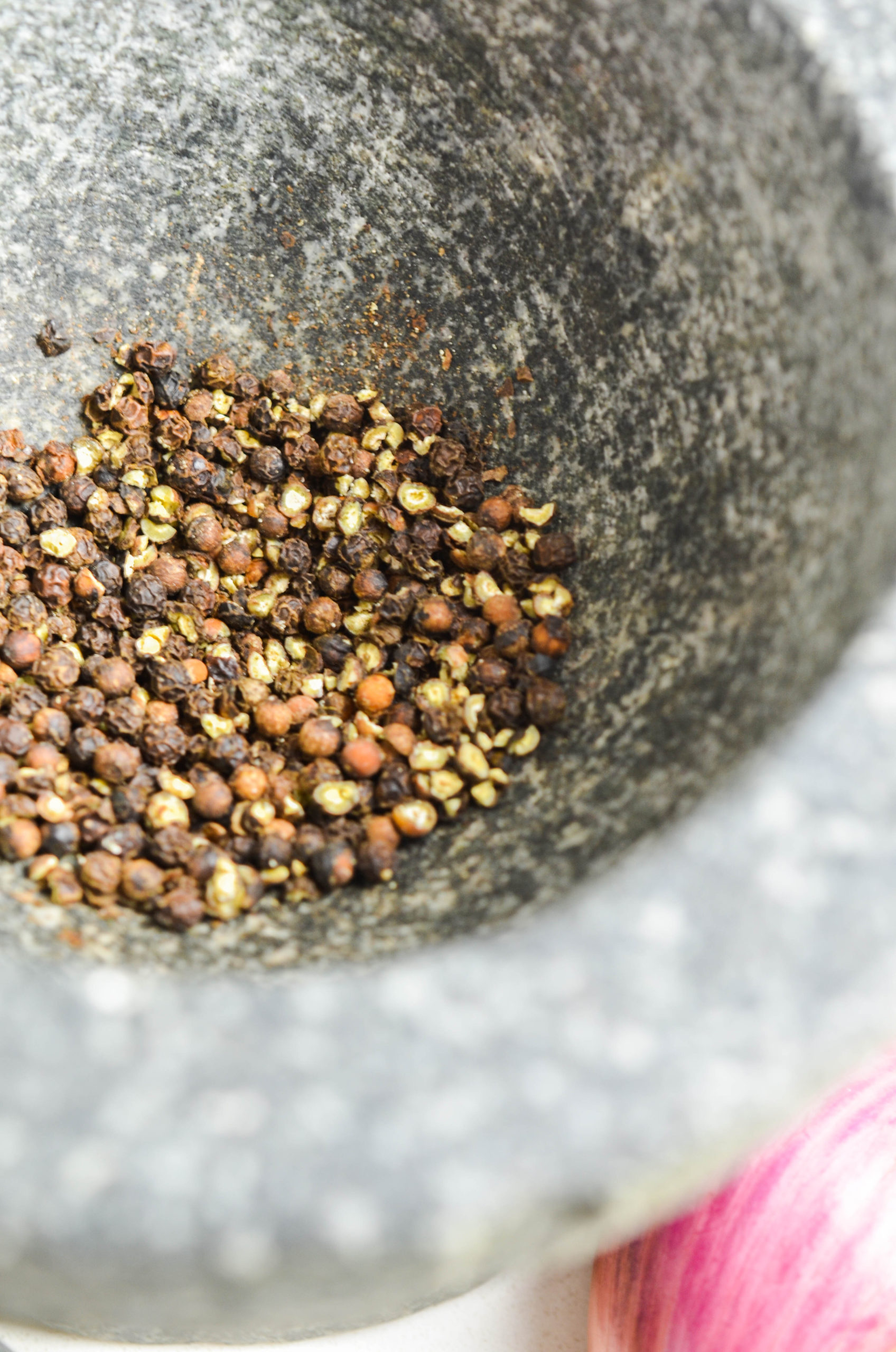 Black peppercorns in a mortar and pestle. 