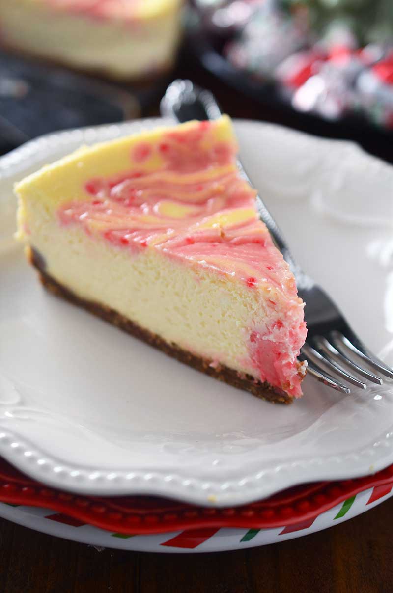 Luscious eggnog cheesecake is swirled with melted Hershey's Candy Cane Kisses in this Peppermint Eggnog Cheesecake making it a perfect holiday treat!