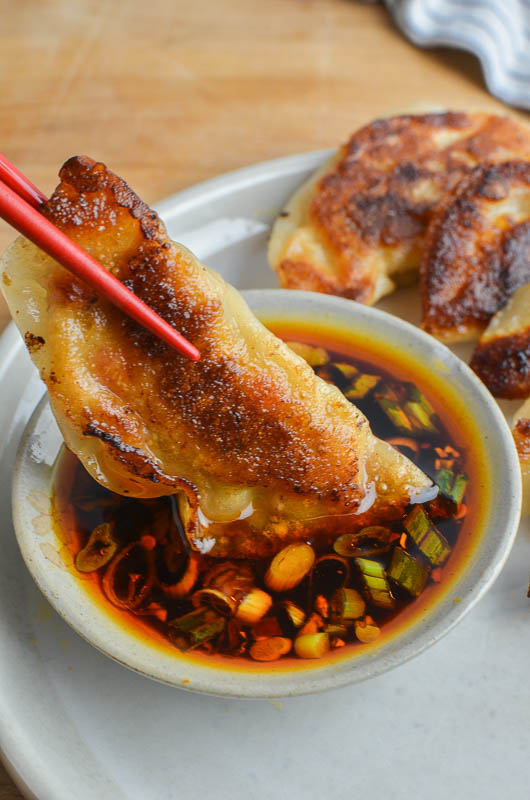 Dipping a potsticker in sauce. 