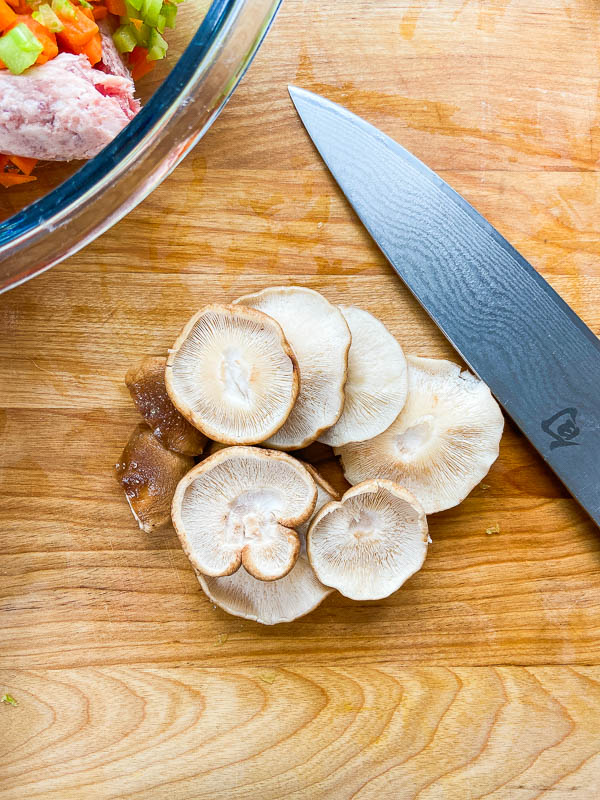 Shiitake mushrooms on a wooden cutting board. 