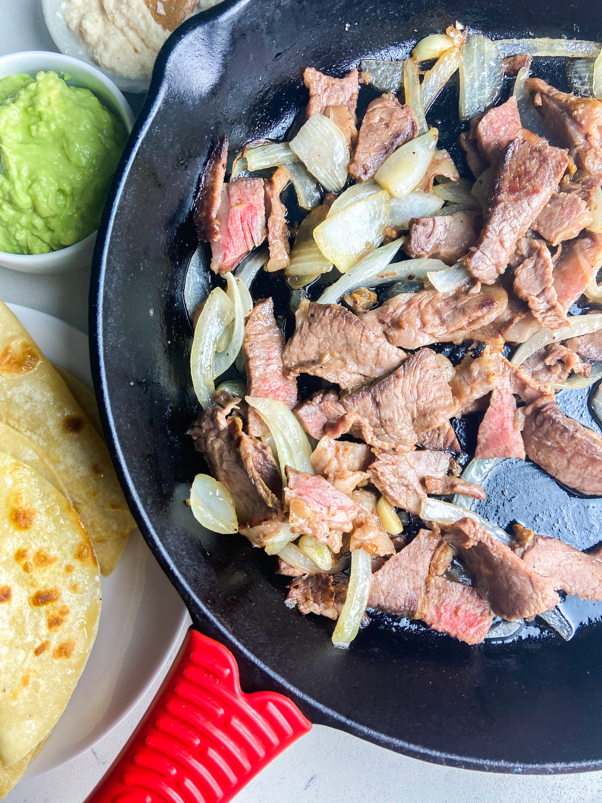 Prime rib and sauteed onions in a cast iron skillet. 