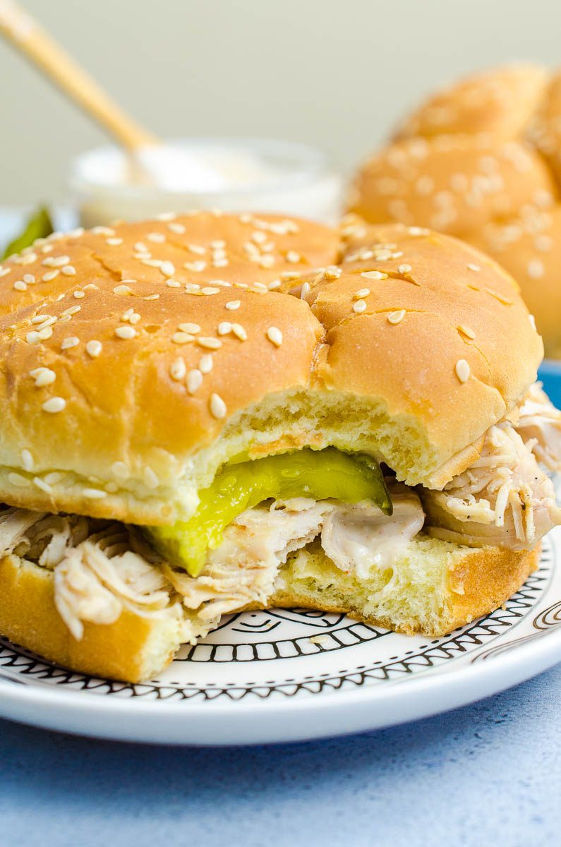 This easy pulled chicken sandwich is made with chicken marinated in Alabama BBQ sauce, grilled, shredded and topped with more Alabama BBQ and bread and butter pickles. The perfect summer sandwich!