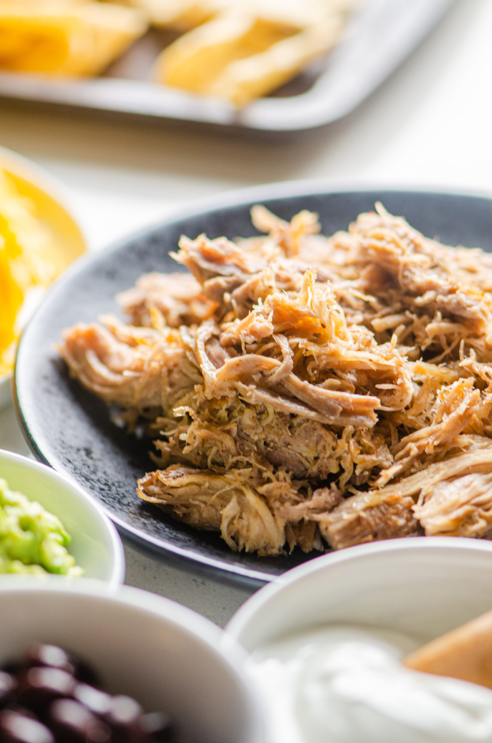 Side angle  photo of shredded pork on a black plate. 