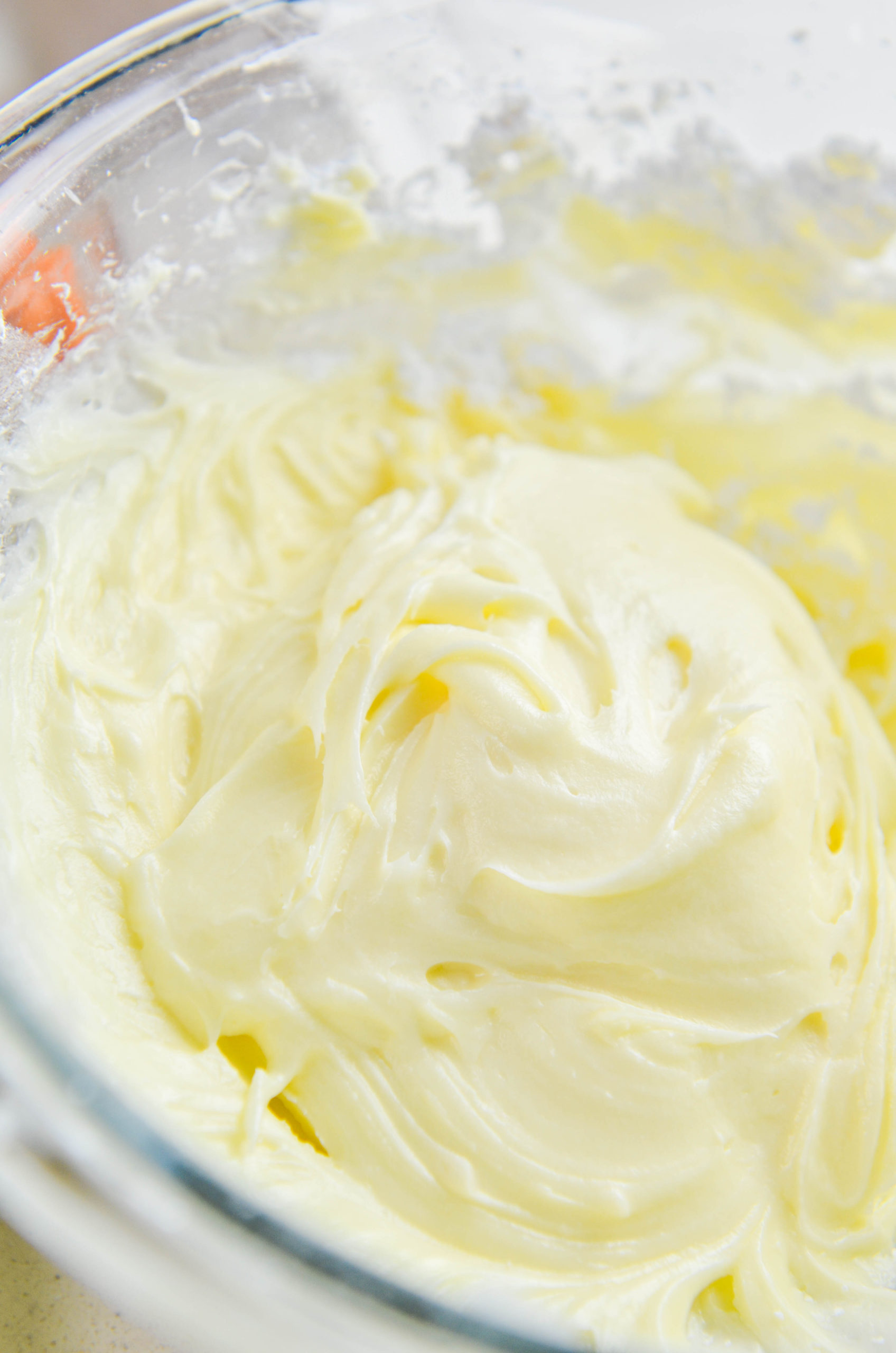 Cream cheese frosting in a glass bowl. 