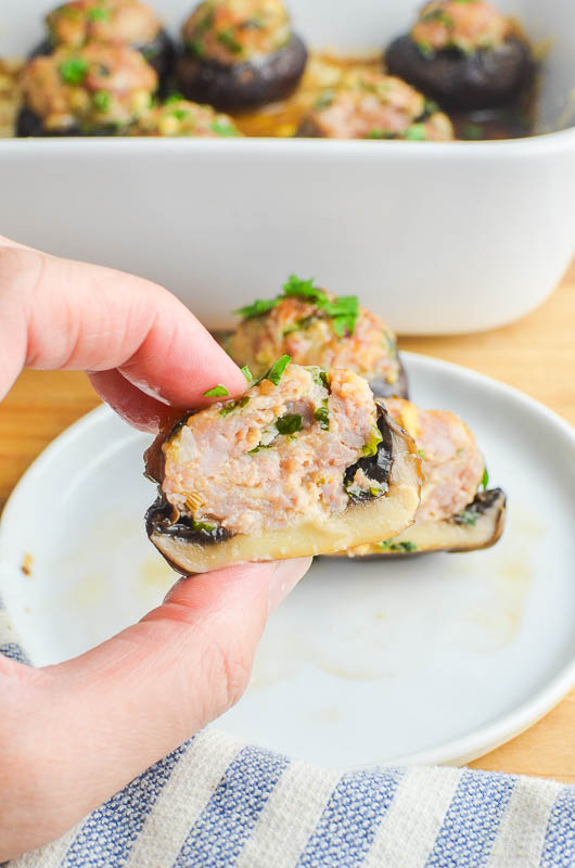 Inside of a sausage stuffed mushroom with a white plate. 