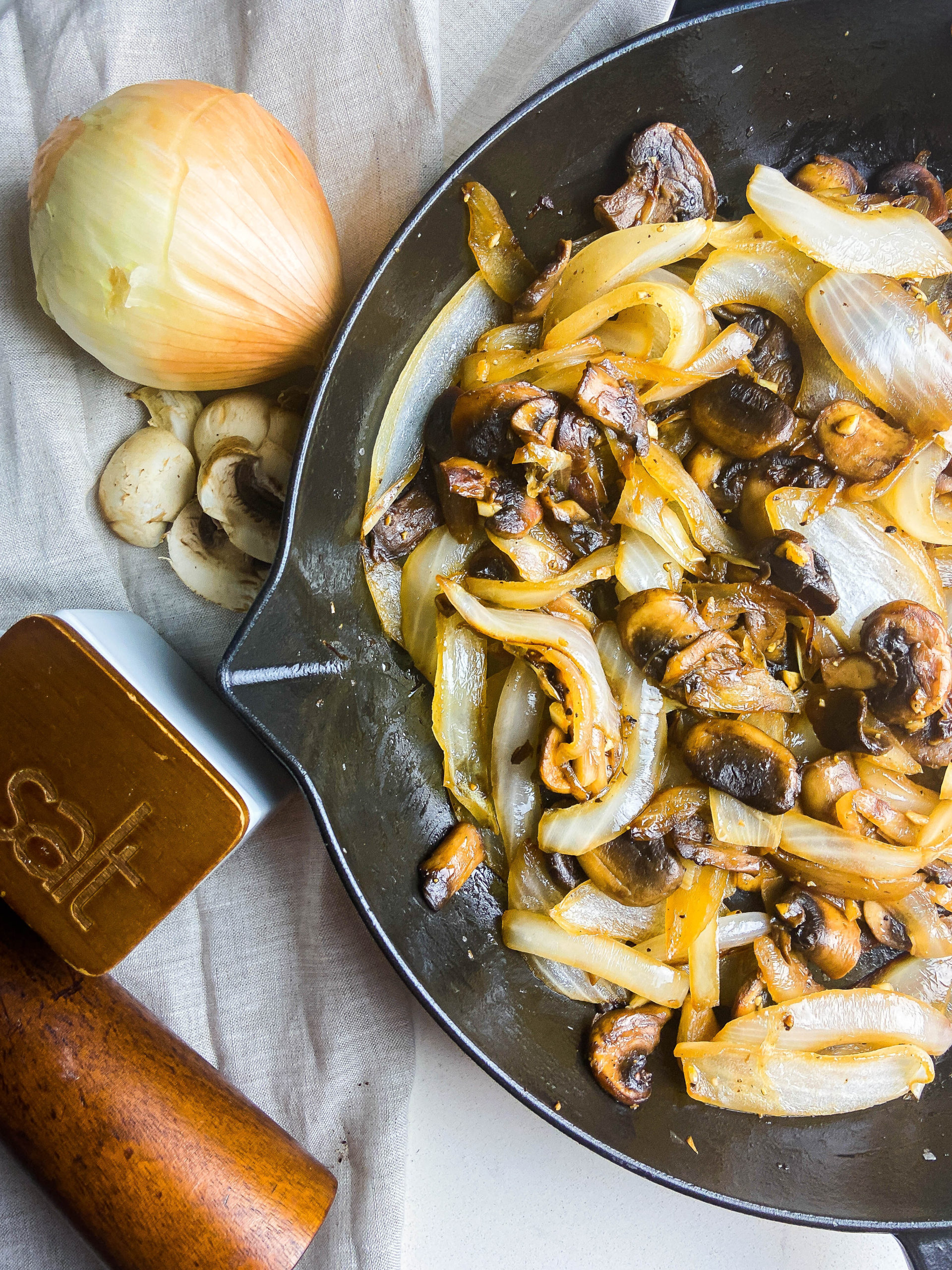 Overhead photo of sauteed mushrooms and onions in a cast iron skillet. 
