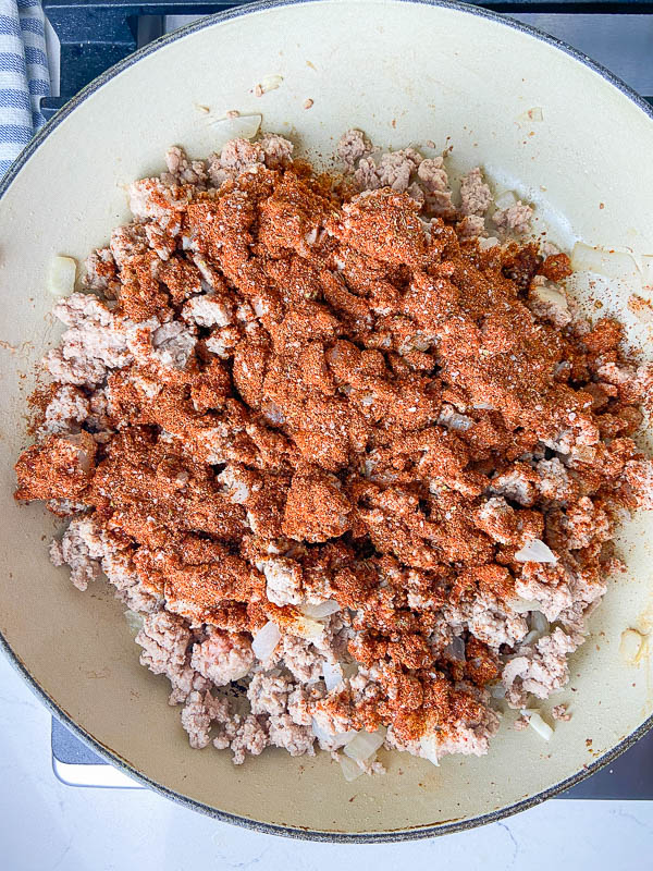 Sprinkled seasoning mixture over meat in a pan. 