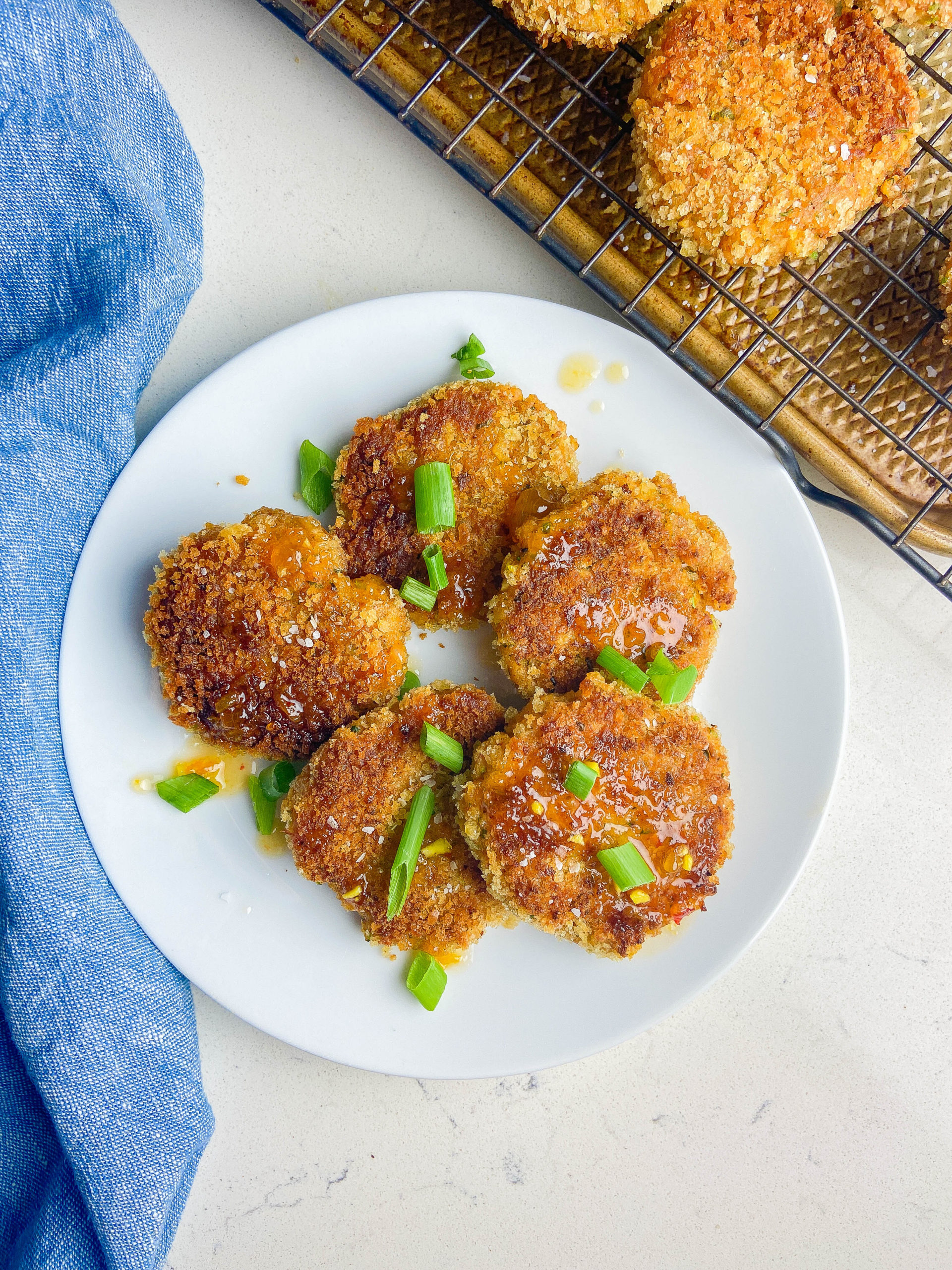 Overhead photo of shrimp cakes on white plate. 