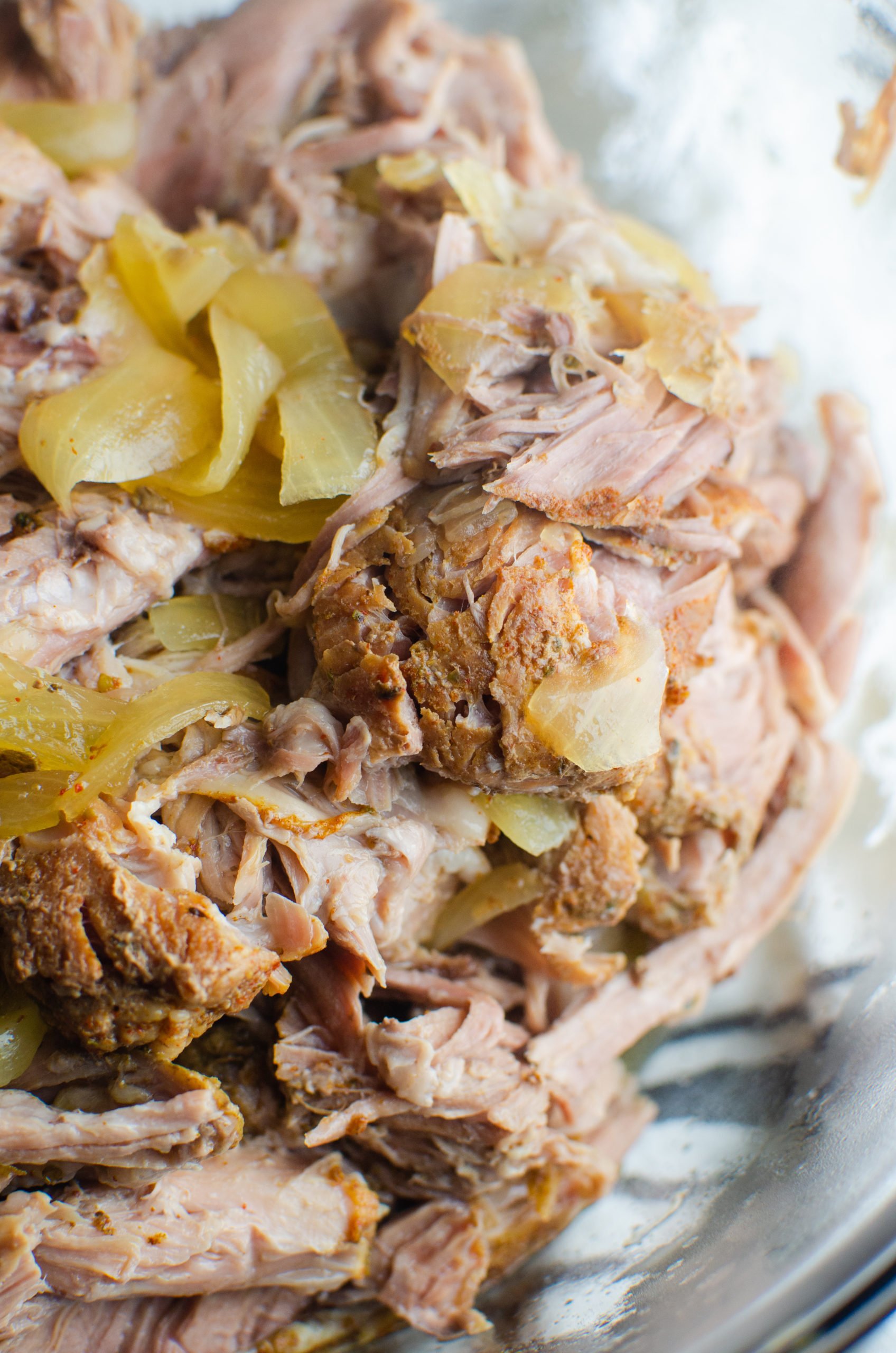 Side angle photo of pulled pork in a glass bowl. 