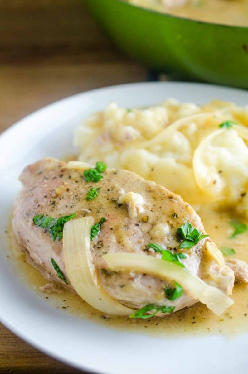 Smothered Pork Chops are a classic for a reason! These sage rubbed pork chops are pan fried and simmered in a savory onion gravy. It's comfort food at it's finest! 