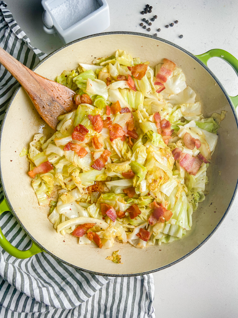 Overhead photo of fried cabbage with bacon in a skillet.