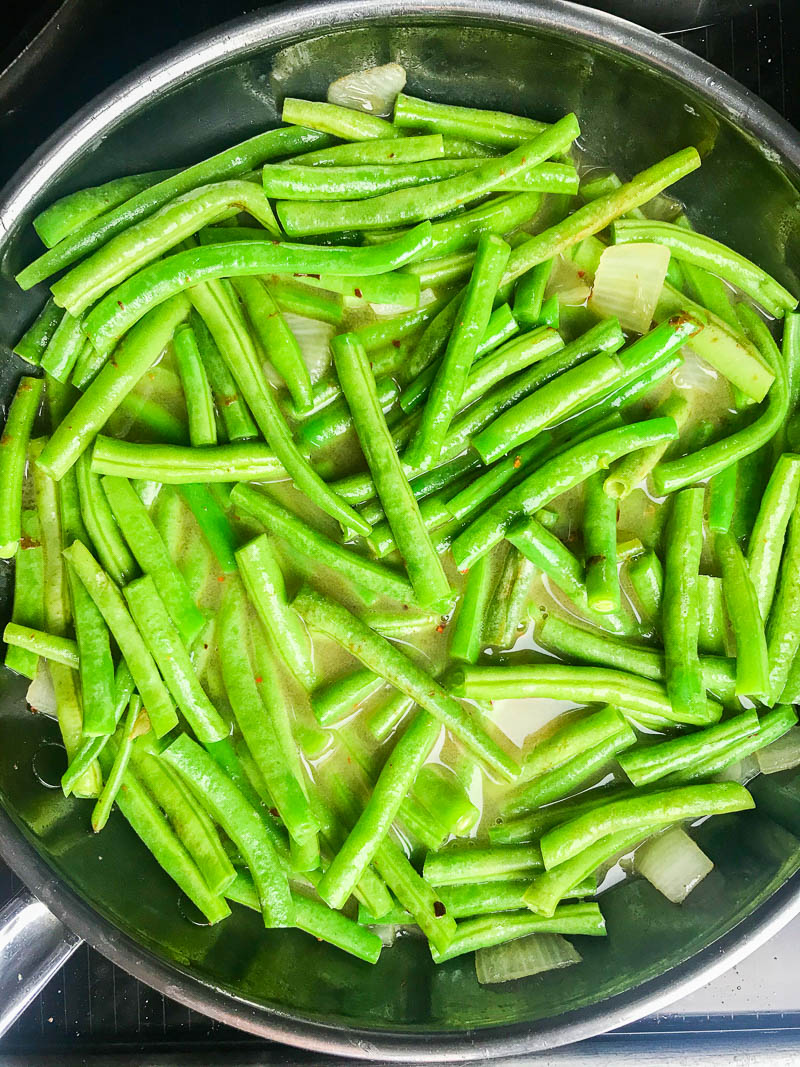 Simmering green beans in chicken broth. 